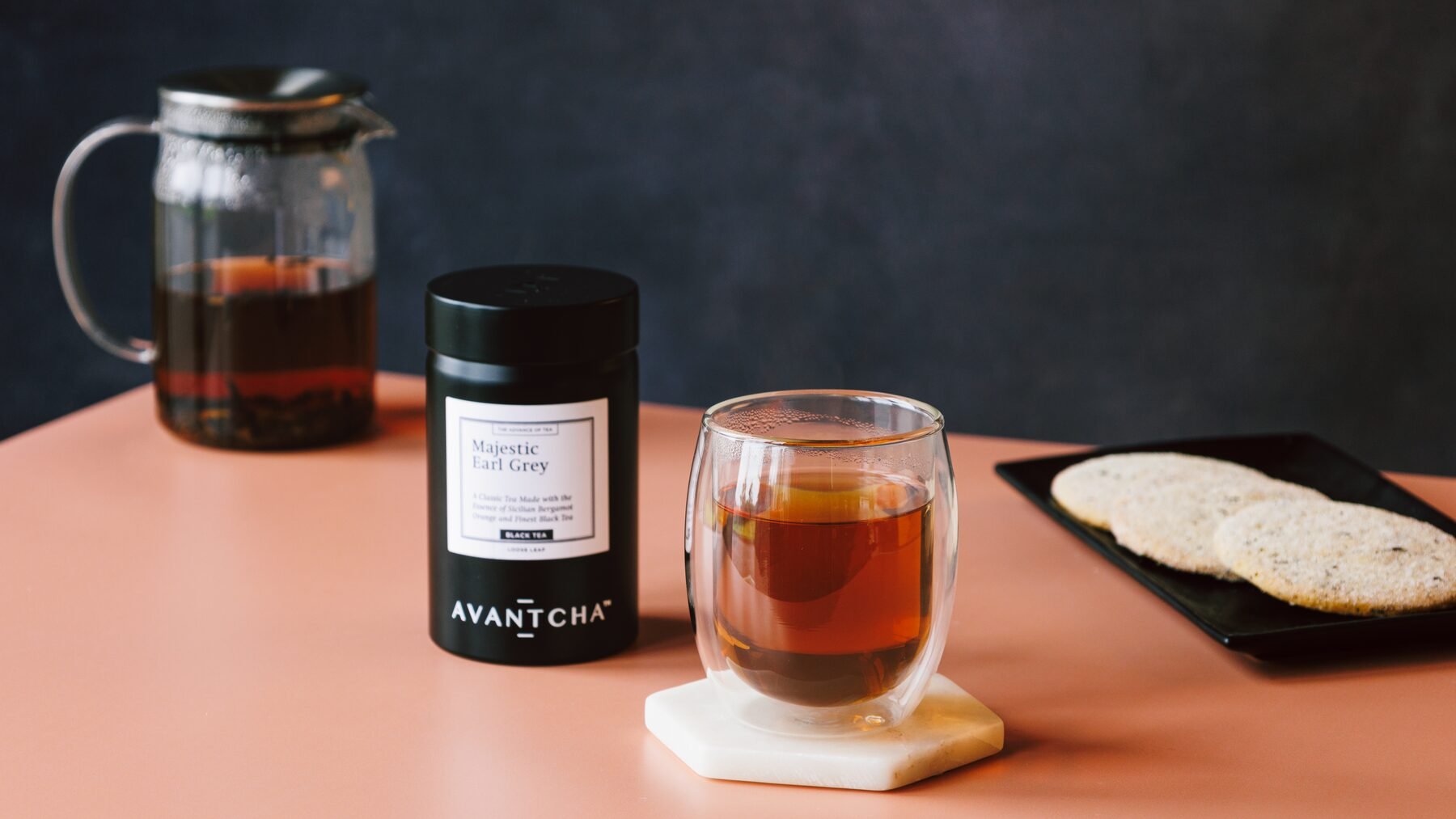 Majestic Earl Grey — kettle, tin, brewed cup and butter cookies on a terracotta surface