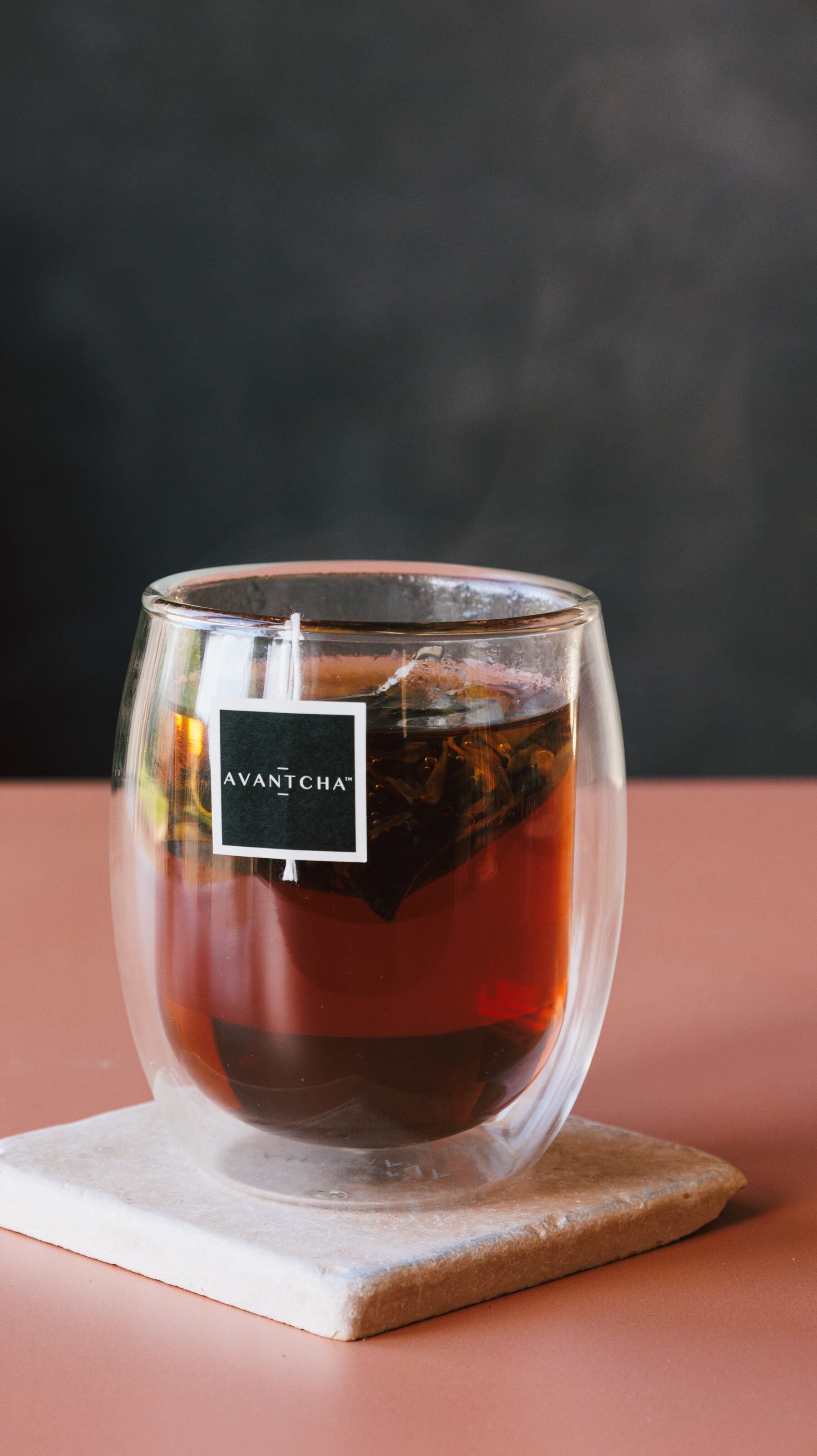 Brewed Majestic Earl Grey steaming in a glass cup on a marble coaster