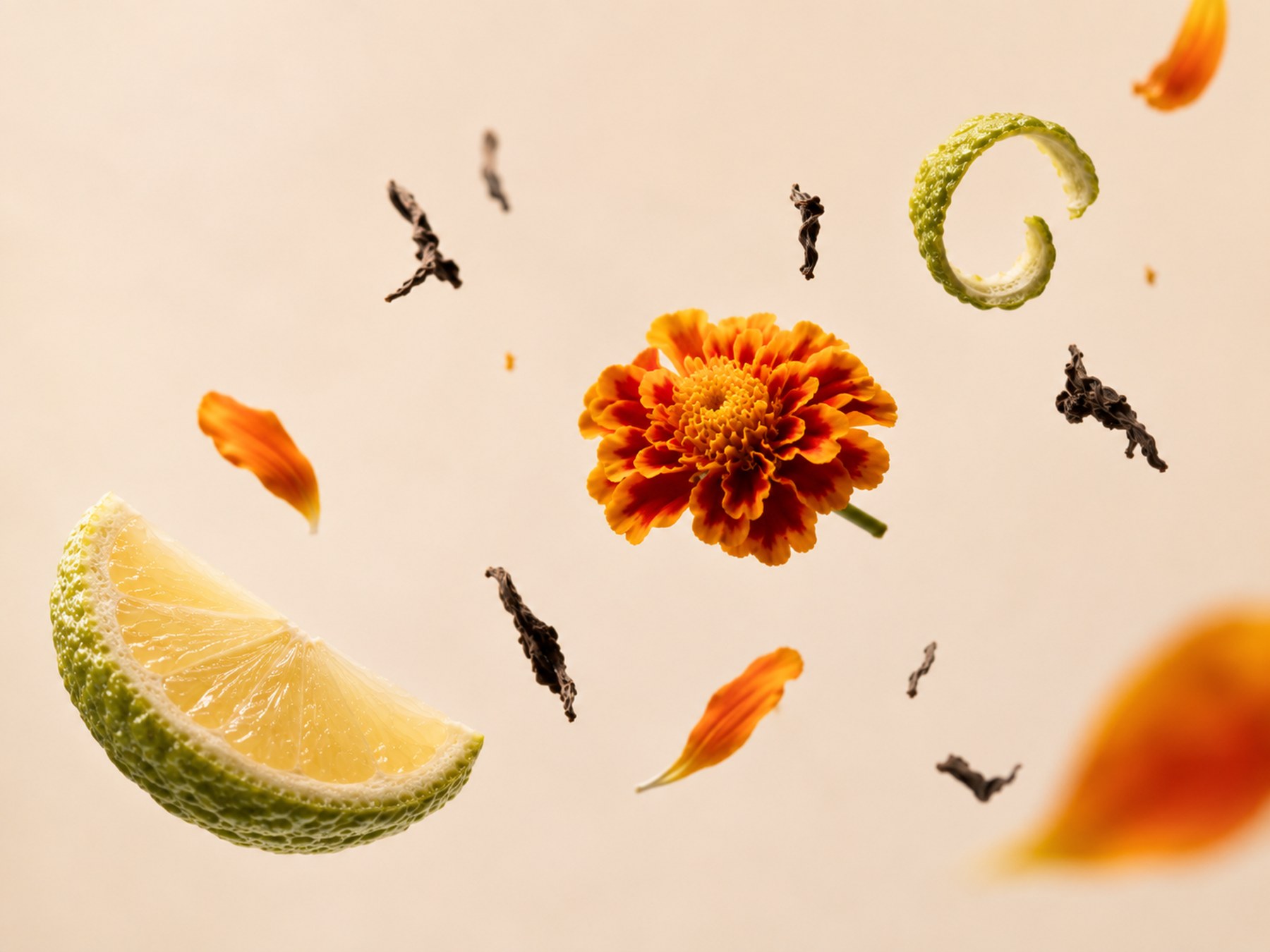 Bergamot peel, marigold petals and black tea leaves suspended against a soft off-white surface